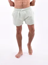 Short de baño blanco con estampado de hojas en tonos azules y rosados, cintura elástica con cordón ajustable.