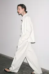 Sobrecamisa blanca de algodón con cuello solapa, manga larga y dos bolsillos de plastrón en el pecho. Cierre frontal con botones ocultos por solapa.