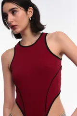 Body de estilo deportivo color bordó con ribetes en contraste color negro. Presenta un diseño de cuello redondo, sin mangas y un corte de pierna alto y pronunciado.