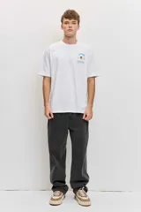 Remera blanca de algodón, de corte clásico y mangas cortas, con un pequeño estampado gráfico al frente en la zona del pecho.