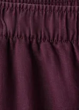 Pantalon de lino color bordo, de corte recto y tiro medio, con cintura elastizada y bolsillos laterales.