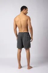 Short de baño de corte relajado en color gris azulado con efecto lavado. Cuenta con cintura elastizada con cordón ajustable, bolsillos laterales y una pequeña etiqueta decorativa en el ruedo.