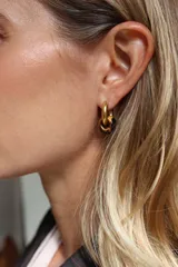Aros tipo argolla pequeña de acero dorado con dije circular de piedra en tono marrón chocolate.