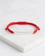 Pulsera de hilo rojo tipo macramé con chapa central de plata 925, diseño minimalista y regulable.
