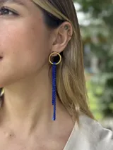 Aro colgante con base dorada, compuesto por un aro superior y tiras largas de strass de color azul cobalto.