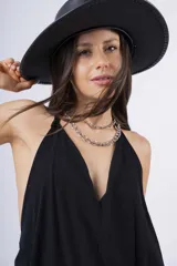 Vestido largo negro con escote en V, breteles finos y falda amplia con volado en el ruedo.