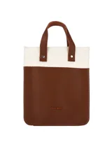 Matera de diseño vertical con combinación de materiales en color beige y marrón. Presenta cuerpo inferior en cuero sintético marrón con logo grabado y sección superior en tejido de lona cruda. Incluye asas cortas de mano en cuero sintético marrón con remaches metálicos.