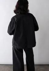 Camisa de estilo vintage confeccionada en algodón reciclado, con cuello clásico, cierre frontal con botones y bolsillos cuadrados en el frente.