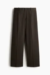 Pantalón sastrero de corte holgado y piernas amplias, color marrón oscuro, con pinzas frontales, pliegues marcados y trabillas para cinturón.