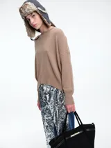 Sweater de punto color negro, con cuello redondo, hombros caídos y terminaciones acanaladas en puños y ruedo. Presenta un diseño de calce relajado y tejido suave.