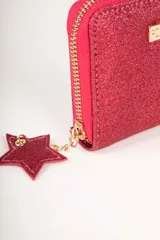 Billetera dorada con glitter, cierre perimetral con cremallera y dije de estrella. Interior con seis ranuras para tarjetas y monedero central con cremallera.