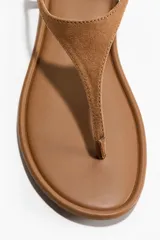 Sandalias planas H&M de dedo, color marrón, con diseño minimalista, punta redonda y tira elástica ajustable en el talón.