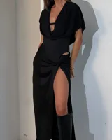 Falda larga negra con abertura lateral alta, corte ajustado en la cintura y drapeado en la cadera.