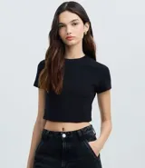 Blusa cropped negra de manga corta y cuello redondo, confeccionada en algodón con elastano.