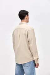 Camisa de corte regular fit confeccionada en algodón, con cuello solapa clásico, cierre frontal con botones y dos bolsillos frontales en el pecho.