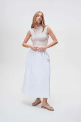 Sandalias bajas de cuero color marrón con detalles de tachas metálicas.