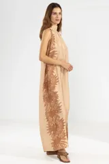 Vestido largo color beige con estampado floral marrón, corte recto, cuello halter y espalda descubierta.