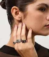 Kit de tres anillos femeninos de metal plateado con diferentes diseños que combinan superficies lisas, arabescos y texturas.