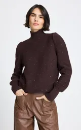 Polera de punto color marrón con cuello alto y mangas largas con puños ajustados. Presenta un sutil diseño de brillos dorados distribuidos por toda la prenda.