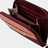 Billetera compacta con cierre de cremallera, color beige y marrón. Presenta paneles de diferentes texturas y el logo de Rip Curl grabado en el frente.