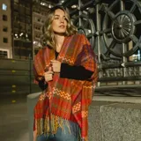 Poncho abierto con diseño de tejido en zigzag multicolor, con flecos en el ruedo.