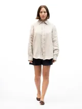 Camisa de manga larga confeccionada en 100% lino natural, con cuello clásico y cierre frontal de botones. Presenta un calce relajado y una textura ligera, ideal para climas cálidos.