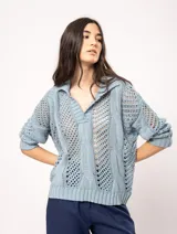 Sweater celeste de punto calado, con cuello polo y mangas largas.