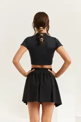 Remera negra de calce ajustado, con mangas cortas y cuello redondo.