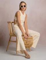 Pantalón de tiro alto con tejido calado y textura labrada, de corte recto con apertura acampanada hacia el ruedo. Cuenta con cintura elastizada y cordón de ajuste con terminaciones de caracoles decorativos.