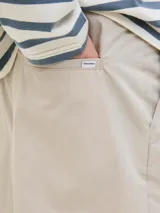 Short color beige de tiro medio con cierre de cremallera, bolsillos delanteros y traseros.