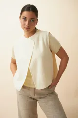 Chaleco color crema de lana fina, con solapa cruzada y mangas japonesas.