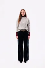 Sweater de punto con textura trenzada, cuello redondo y mangas largas. Presenta un diseño de silueta relajada y tejido abrigado.