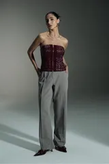 Corset rojo con cierre frontal con cremallera dorada y diseño geométrico en relieve.