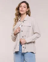 Sobrecamisa beige de lino liviano, con cuello camisero, cierre frontal de botones carey y bolsillos en el pecho. Cuenta con cordón ajustable en la cintura y mangas largas.