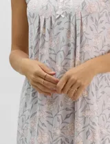 Camisón corto de tejido soft, sin mangas, con escote redondo, aplique de botones y detalle plisado en el frente. Estampado floral en tonos rosados y grises.