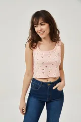 Musculosa rosa con estampado de margaritas blancas y amarillas, de bretel ancho, corte al cuerpo y cuello redondo.