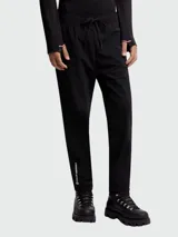 Pantalón deportivo negro de corte recto, con cintura elástica ajustable con cordón. Presenta el logo de Moncler Grenoble estampado en blanco en la parte inferior de la pierna izquierda.