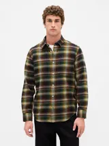 Camisa de manga larga confeccionada en tela de franela con estampado de cuadros en tonos verdes, marrones y amarillos. Presenta cuello clásico, cierre frontal con botones y un bolsillo en el pecho.