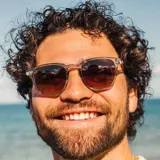 Lentes de sol Sunski modelo Tango, con montura transparente grisácea y lentes marrones degradé.