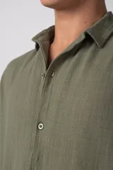 Camisa de manga corta confeccionada en lino, con cuello clásico y cierre frontal de botones. Presenta un corte relajado y textura liviana.