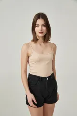 Musculosa color beige con breteles finos y escote redondo.