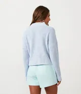 Short pollera de material sintético color celeste, con diseño cruzado en la parte delantera y cierre lateral con cremallera.