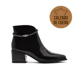 Bota corta de vestir Marco Donatti, confeccionada en cuero charol negro, con taco cuadrado y detalle de cadena metálica fina alrededor del tobillo.