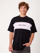 Remera holgada Rusty con diseño de bloques de color negro y blanco, cuello ancho y logo de la marca estampado en el pecho.
