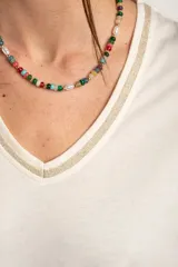 Remera de algodón peinado color marfil, de manga corta y corte al cuerpo, con escote en V ribeteado con hilo dorado.