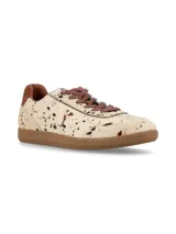 Sneaker deportivo de cuero con pelo, con estampado tipo animal print de manchas en tonos marrones y negros sobre base cruda. Presenta suela de goma color miel, cordones marrón y detalle de talón en cuero liso.