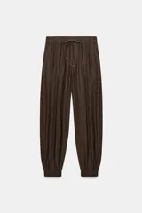 Pantalón jogger de tiro bajo color marrón, con cintura elástica ajustable con cordón, bolsillos delanteros y puños elásticos en los tobillos.