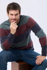 Remera de manga larga con diseño de franjas horizontales en tonos verde militar, bordó y azul marino, con cuello redondo y pequeño texto estampado en el pecho.