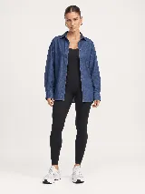 Camisa de denim azul con diseño oversize, cuello camisero, manga larga y cierre frontal de botones.