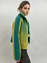 Chaqueta de lana merino afieltrada con diseño en degradé de tonos verdes y amarillos. Presenta un corte recto, cuello alto, mangas largas y bolsillos laterales.